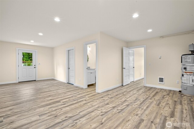 691 N W Camano Dr, Camano Island, WA 98282 - unfurnished living room with water heater, baseboards, light wood finished floors, and recessed lighting