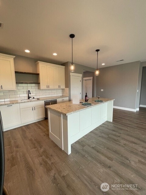 9 Columbia View Dr, Brewster, WA 98812 - kitchen featuring stainless steel dishwasher, a sink, dark wood-style floors, a center island, and white cabinets