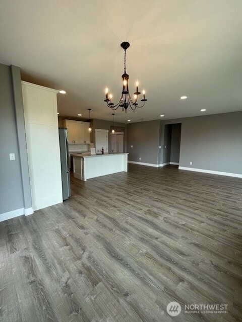 9 Columbia View Dr, Brewster, WA 98812 - unfurnished living room with a chandelier, baseboards, recessed lighting, and dark wood-style flooring