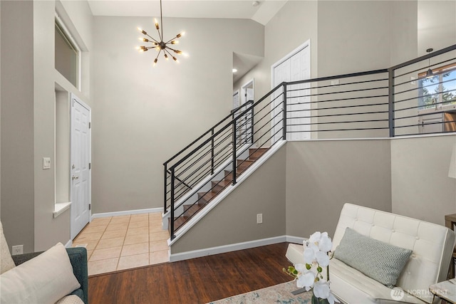 13014 97th Ave NW, Gig Harbor, WA 98329 - stairway with a chandelier, wood finished floors, high vaulted ceiling, and baseboards