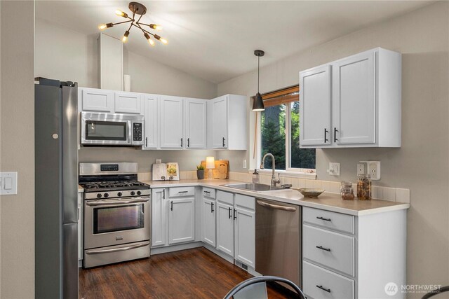 13014 97th Ave NW, Gig Harbor, WA 98329 - kitchen with stainless steel appliances, a sink, dark wood-style floors, white cabinets, and vaulted ceiling