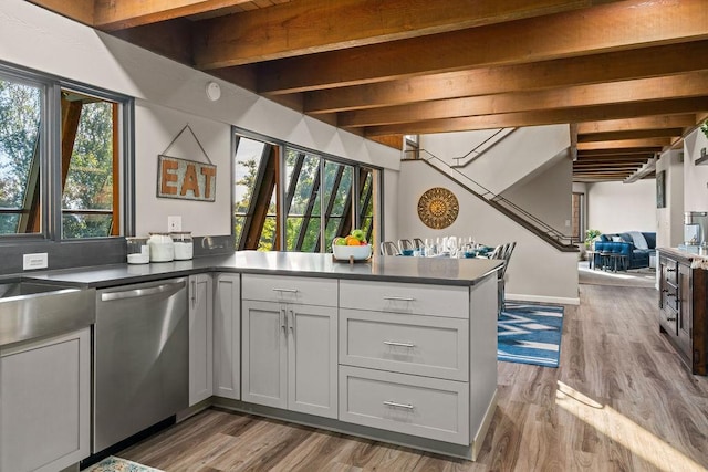 4706 Scenic Dr, Yakima, WA 98908 - kitchen with stainless steel dishwasher, a peninsula, wood finished floors, beam ceiling, and dark countertops