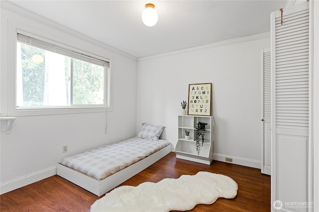 bedroom featuring baseboards, wood finished floors, and ornamental molding