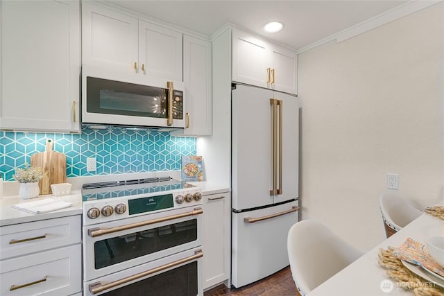 kitchen featuring high quality appliances, light countertops, white cabinets, crown molding, and recessed lighting