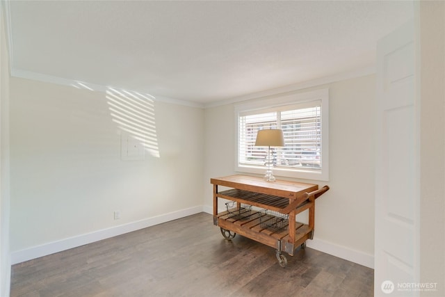 interior space featuring crown molding, wood finished floors, and baseboards