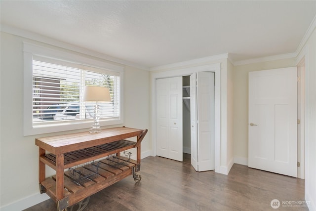 dining area with wood finished floors, crown molding, and baseboards