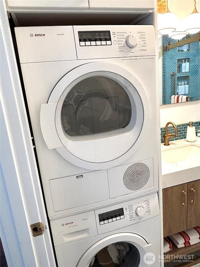 laundry area featuring stacked washer / drying machine