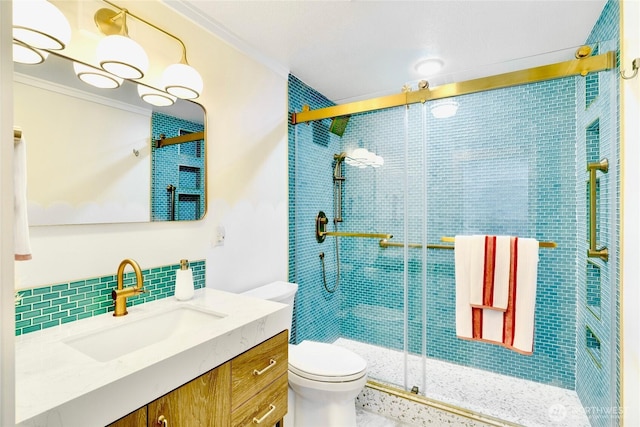 bathroom featuring backsplash, toilet, vanity, a shower stall, and crown molding