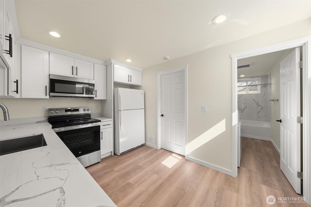 8322 Wabash Ave S, Seattle, WA 98118 - kitchen featuring stainless steel appliances, a sink, white cabinets, light wood-style floors, and recessed lighting
