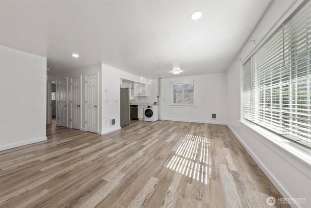 8322 Wabash Ave S, Seattle, WA 98118 - unfurnished living room with washer / dryer, light wood finished floors, baseboards, and recessed lighting