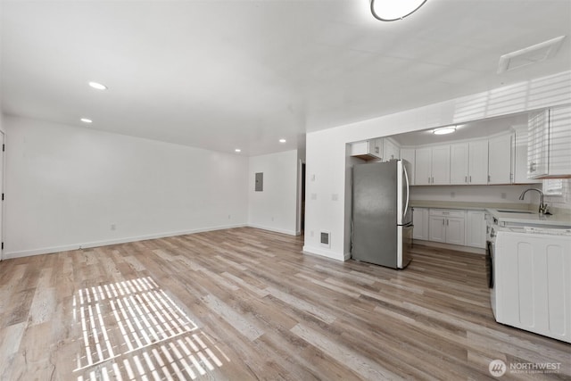 8322 Wabash Ave S, Seattle, WA 98118 - kitchen with freestanding refrigerator, light countertops, light wood-style floors, a sink, and recessed lighting