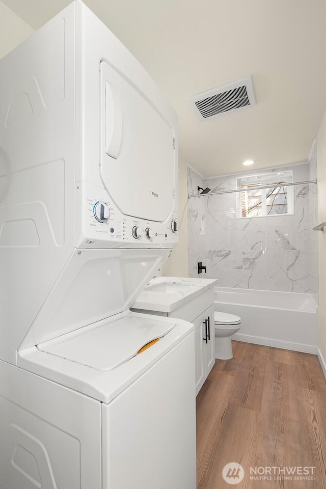 8322 Wabash Ave S, Seattle, WA 98118 - full bathroom with estacked washer and dryer, toilet, wood finished floors, washtub / shower combination, and vanity