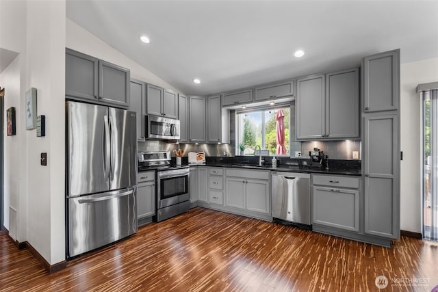 2419 53rd Street Ct NW, Gig Harbor, WA 98335 - kitchen with stainless steel appliances, gray cabinetry, dark countertops, backsplash, and vaulted ceiling