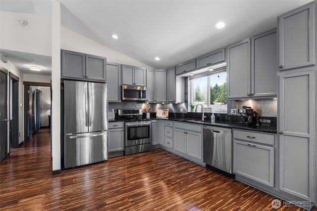 2419 53rd Street Ct NW, Gig Harbor, WA 98335 - kitchen with stainless steel appliances, gray cabinetry, a sink, vaulted ceiling, and decorative backsplash