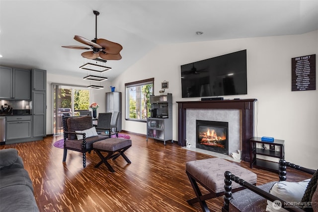 2419 53rd Street Ct NW, Gig Harbor, WA 98335 - living area with dark wood-style flooring, lofted ceiling, a ceiling fan, a tiled fireplace, and baseboards
