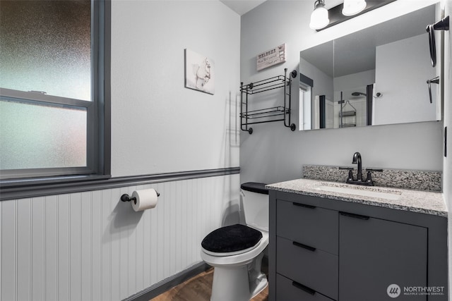 2419 53rd Street Ct NW, Gig Harbor, WA 98335 - bathroom featuring toilet, vanity, wainscoting, and wood finished floors