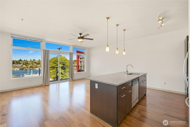2960 Eastlake Ave E Unit 307, Seattle, WA 98102 - kitchen with stainless steel appliances, a sink, a ceiling fan, open floor plan, and light wood-type flooring