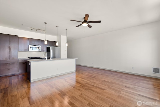 2960 Eastlake Ave E Unit 307, Seattle, WA 98102 - kitchen featuring stainless steel appliances, a ceiling fan, dark brown cabinetry, and light wood-style flooring