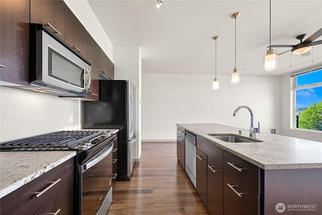 2960 Eastlake Ave E Unit 307, Seattle, WA 98102 - kitchen featuring appliances with stainless steel finishes, a sink, dark wood-type flooring, an island with sink, and dark brown cabinets