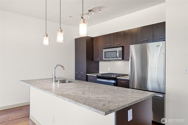 2960 Eastlake Ave E Unit 307, Seattle, WA 98102 - kitchen with appliances with stainless steel finishes, a sink, dark brown cabinets, an island with sink, and light wood finished floors