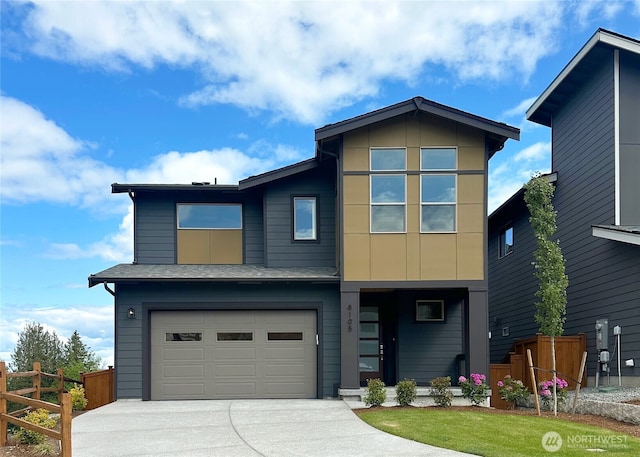 contemporary home with fence, concrete driveway, and a garage