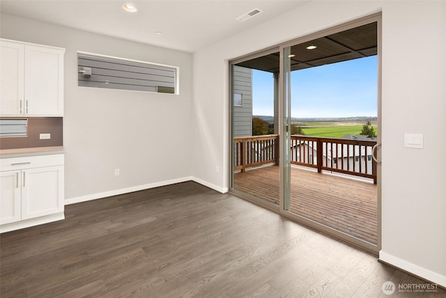 unfurnished room featuring wood finished floors, baseboards, and recessed lighting
