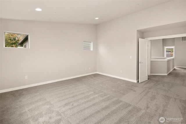 spare room featuring carpet floors, baseboards, plenty of natural light, and recessed lighting