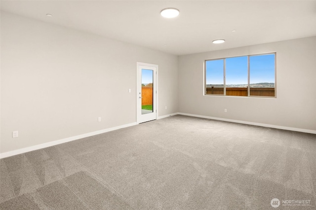 carpeted empty room with baseboards and recessed lighting