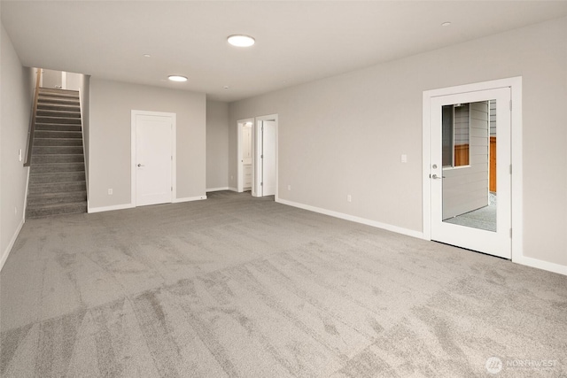 carpeted empty room with baseboards, stairway, and recessed lighting