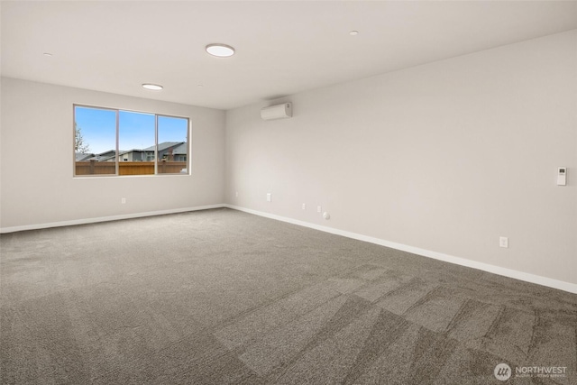 unfurnished room with carpet flooring, a wall mounted AC, and baseboards