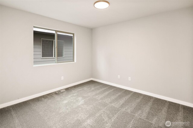 carpeted empty room featuring baseboards
