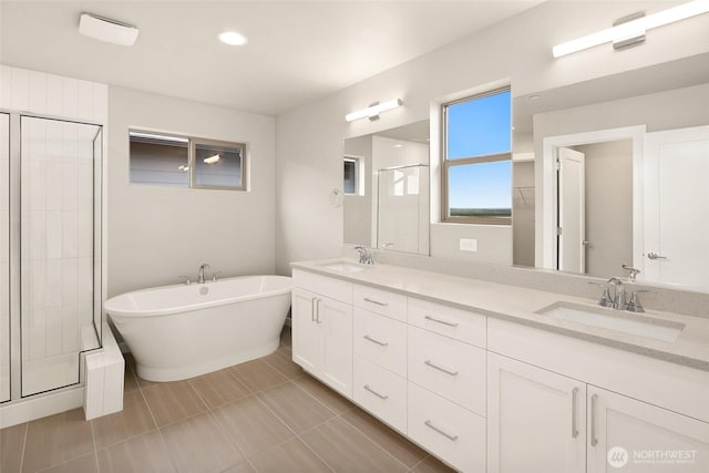 full bathroom with a stall shower, double vanity, a soaking tub, tile patterned floors, and recessed lighting