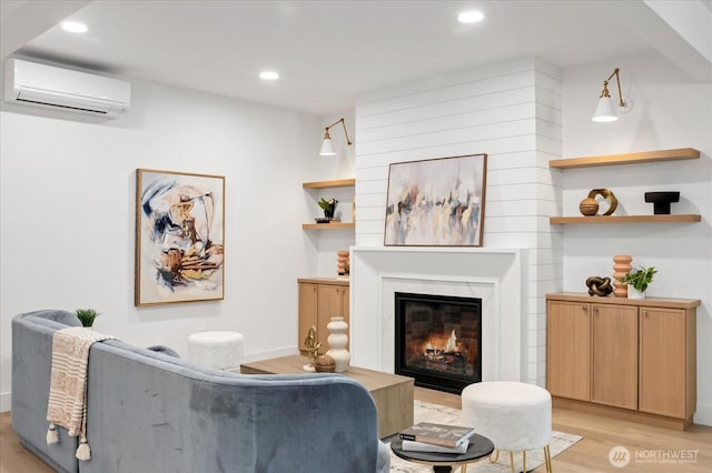 sitting room featuring a wall mounted AC, light wood-type flooring, recessed lighting, a fireplace, and baseboards