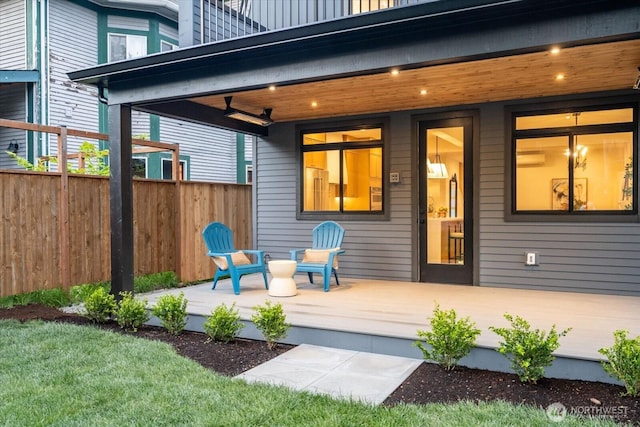 entrance to property featuring covered porch and fence