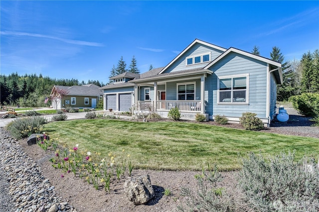 view of front of property with covered porch, a front yard, an attached garage, and concrete driveway