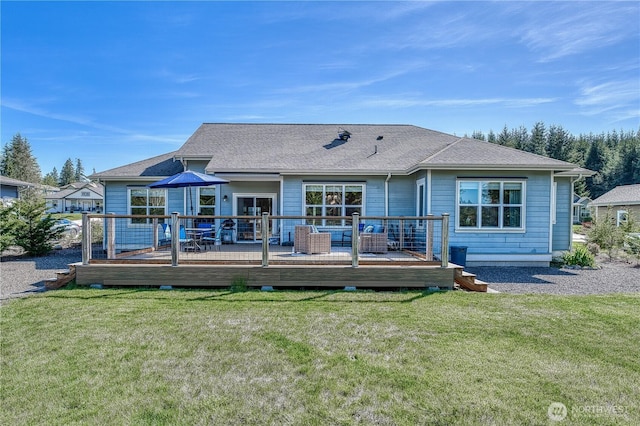back of house with a yard, a wooden deck, and a shingled roof