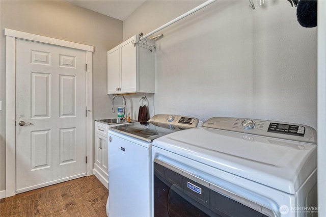 laundry room with cabinet space, washer and clothes dryer, and dark wood finished floors