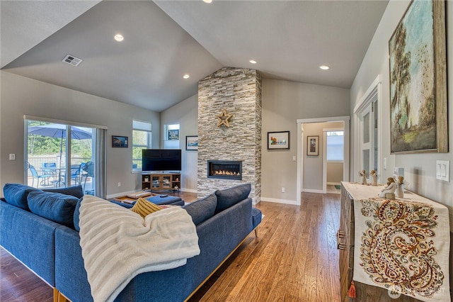 living area with wood finished floors, a stone fireplace, baseboards, high vaulted ceiling, and recessed lighting