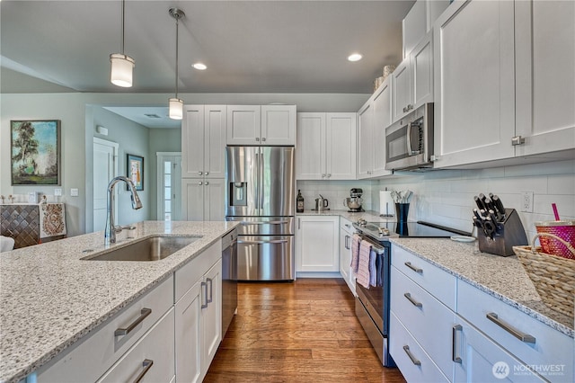 kitchen with stainless steel appliances, a sink, white cabinetry, pendant lighting, and light stone countertops