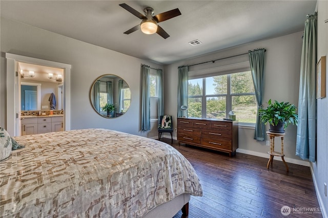 bedroom with baseboards, dark wood finished floors, ensuite bath, and ceiling fan
