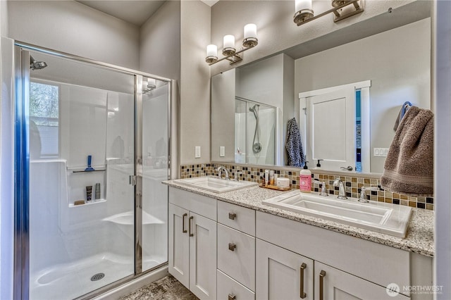 full bath with a shower stall, backsplash, and double vanity