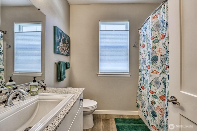 bathroom with toilet, baseboards, vanity, and a shower with curtain