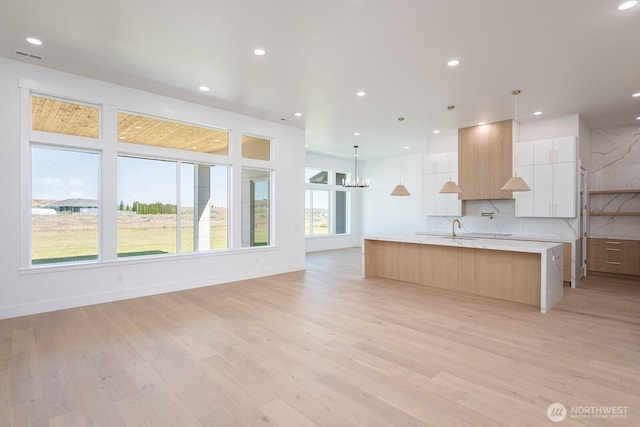 6773 Rd E.2 NE, Moses Lake, WA 98837 - kitchen featuring modern cabinets, light countertops, a spacious island, light wood-style flooring, and recessed lighting