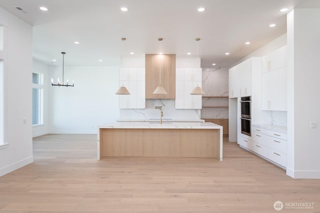 6773 Rd E.2 NE, Moses Lake, WA 98837 - kitchen with double oven, modern cabinets, a large island, light wood-type flooring, and recessed lighting