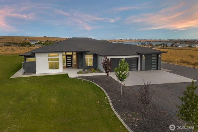 6773 Rd E.2 NE, Moses Lake, WA 98837 - back of house featuring an attached garage, driveway, a lawn, and roof with shingles