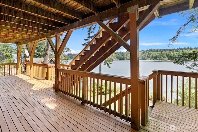 wooden terrace featuring stairway and a water view