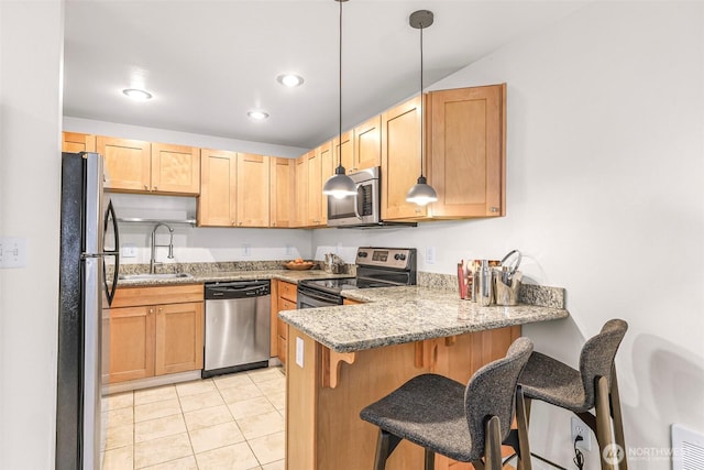 kitchen with stainless steel appliances, a sink, a peninsula, light tile patterned floors, and a kitchen breakfast bar