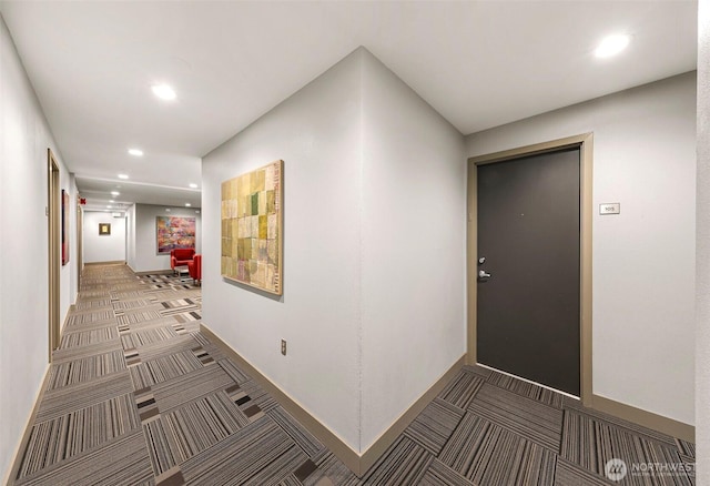 hallway featuring recessed lighting, light carpet, and baseboards
