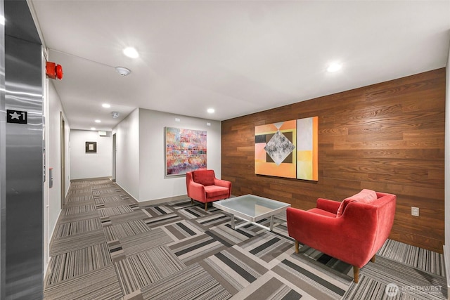 common area with wood walls and recessed lighting