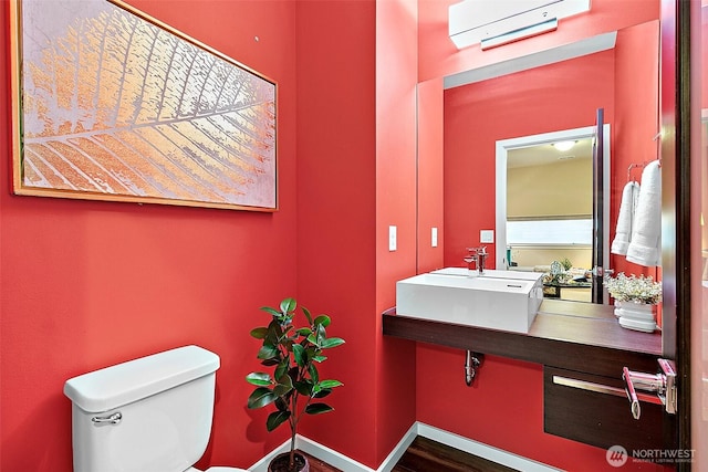 30429 121st Pl SE, Auburn, WA 98092 - bathroom with a wall mounted AC, a sink, toilet, baseboards, and wood finished floors